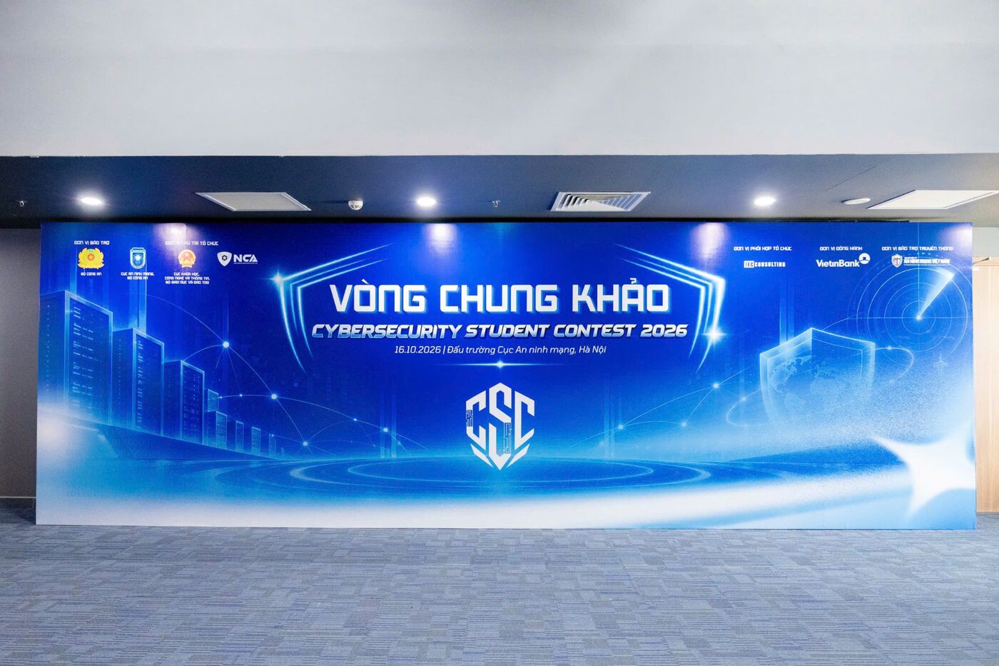 The finals venue backdrop in Hanoi, a lit wall reading Vong Chung Khao, Cybersecurity Student Contest 2026
